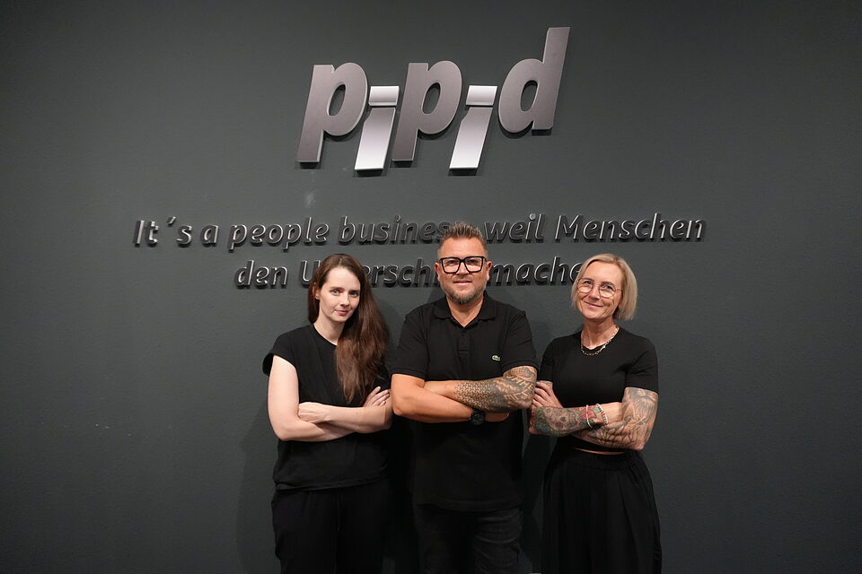 Bianca Raković, Marc Vonhofen und Melanie Vonhofen vor dem P-P-D-Schriftzug und dem Motto „It’s a people business“ im Büro in Eschweiler
